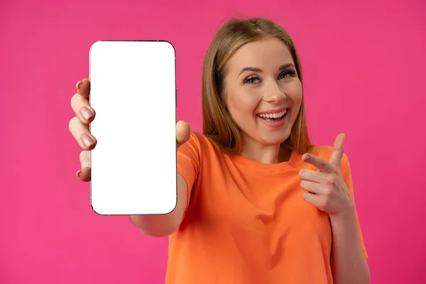 Mulher jovem mostrando smartphone com tela branca isolada contra fundo de cor — Fotografia de Stock