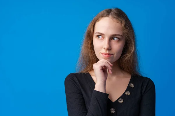 Retrato de menina bonita adolescente pensando e criando solução contra o fundo azul — Fotografia de Stock