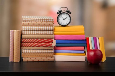 Bulanık arka plana karşı ahşap masadaki kitap yığını