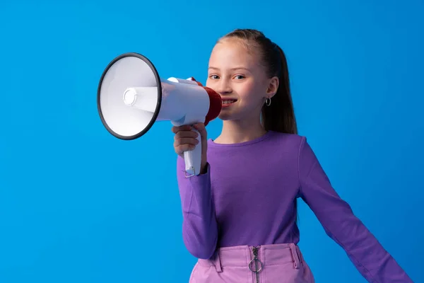 Menina criança usando megafone contra fundo azul — Fotografia de Stock