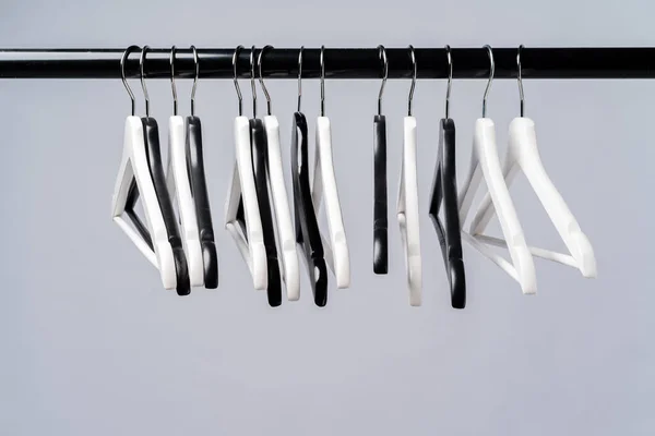 Металлическая стойка с вешалками для одежды на сером фоне — стоковое фото