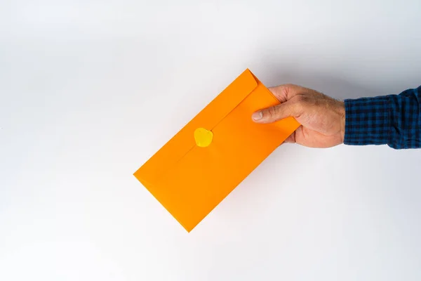 Mężczyzna trzyma zamkniętą kopertę nad białą powierzchnią — Zdjęcie stockowe