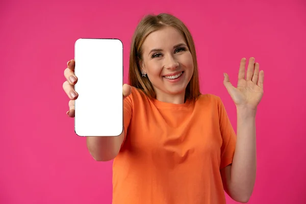 若いです女性は、色の背景に隔離された白い画面でスマートフォンを示す — ストック写真