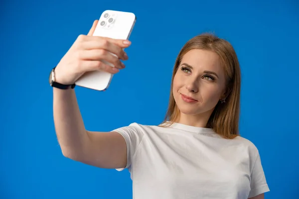 Mujer feliz tomando selfie contra fondo de color de estudio — Foto de Stock
