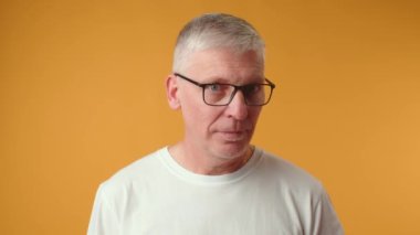 Yakışıklı, gözlüklü, korkmuş ve şaşırmış bir adam.