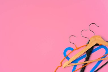 Pembe arkaplandaki boş askılarla düz konum