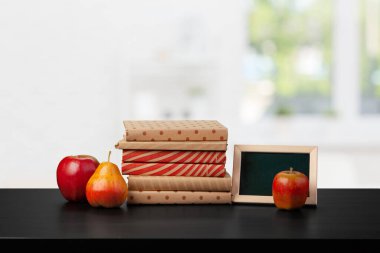 Bulanık arka plana karşı ahşap masadaki kitap yığını