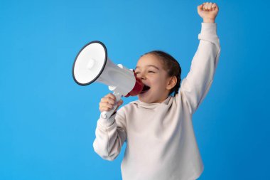 Mavi arka planda megafon kullanan kız çocuğu