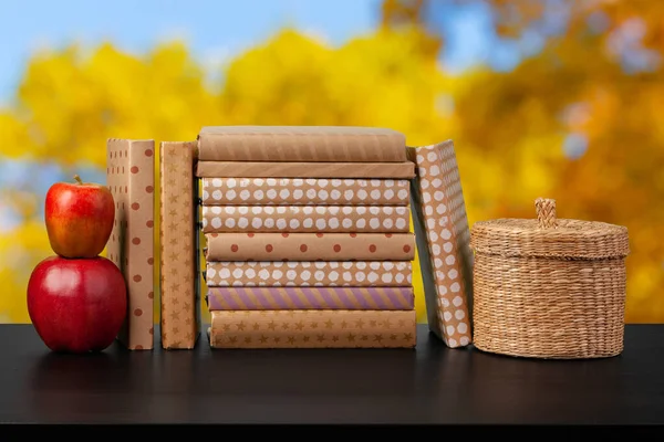 Стопка книг на деревянном столе на размытом фоне — стоковое фото
