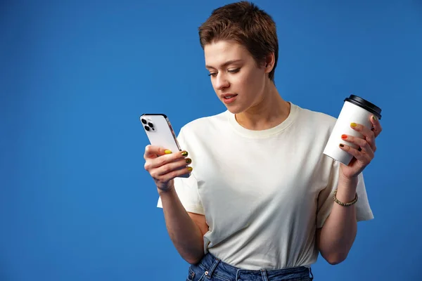 Menina agradável feliz usando celular isolado sobre fundo azul — Fotografia de Stock