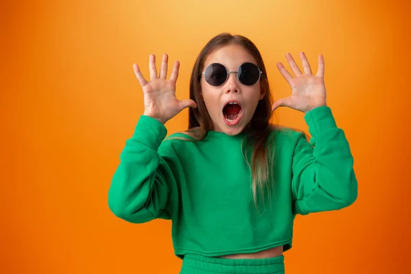 Смішна біла дівчина-підліток в окулярах ізольована на помаранчевому фоні — стокове фото