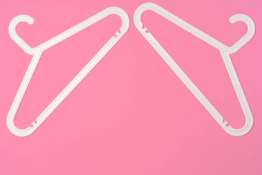 Pembe arkaplandaki boş askılarla düz konum