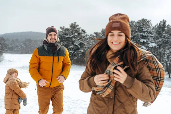 Happy family having a walk in winter outdoors in snow — Stock Photo, Image