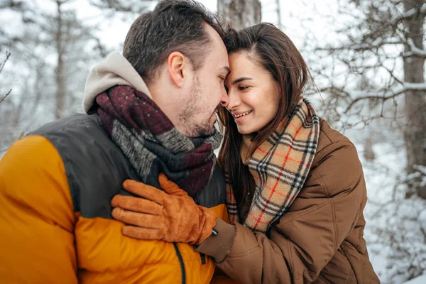 Young couple in love outdoor in snowy winter forest. — Stock Photo, Image