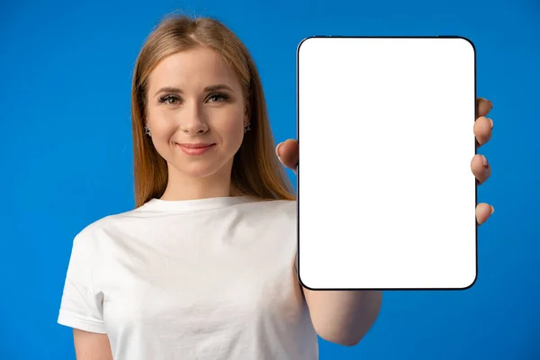 Mulher branca jovem apontando seu tablet digital com tela em branco para o seu design em fundo de cor — Fotografia de Stock
