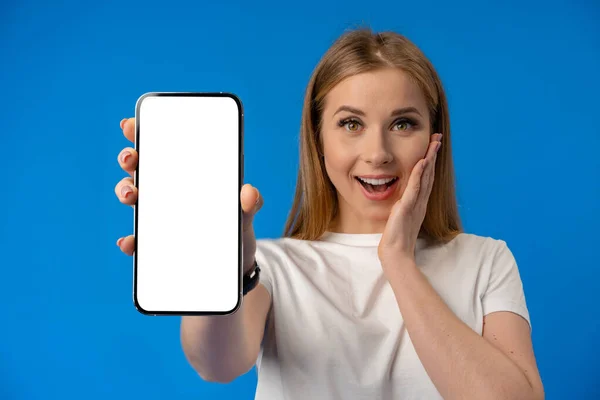 Jovem dedo apontador da mulher na tela isolada do smartphone sobre fundo de cor azul — Fotografia de Stock