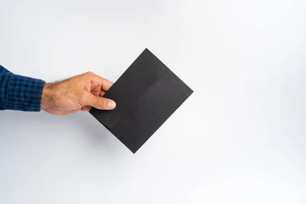 Male hand holding closed envelope above the white surface — Stock Photo, Image