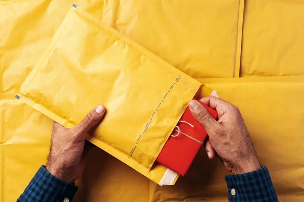 पुरुष हाथ शिपिंग के लिए पीले बुलबुले लिफाफे पैकिंग . — स्टॉक फ़ोटो, इमेज
