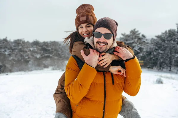 Young couple in love outdoor in snowy winter forest. — Stock Photo, Image