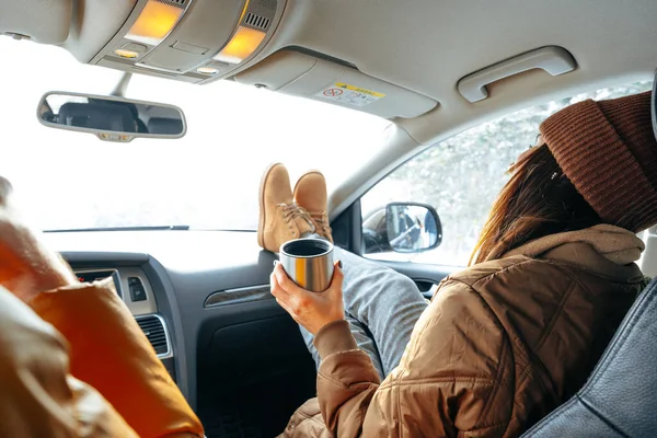 Красива молода жінка в теплому одязі сидить в машині під час зимової подорожі — стокове фото