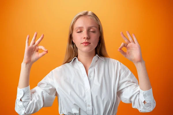 Teenager Schulmädchen über isolierten orangefarbenen Hintergrund in Zen-Pose — Stockfoto