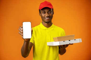 Afrikalı kurye boş ekranlı akıllı telefonu stüdyoda tutuyor.