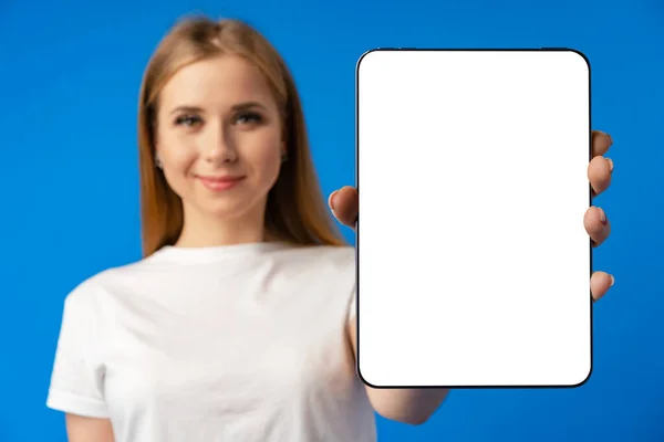 Jeune femme caucasienne pointant sa tablette numérique avec écran vierge pour votre conception sur fond de couleur — Photo