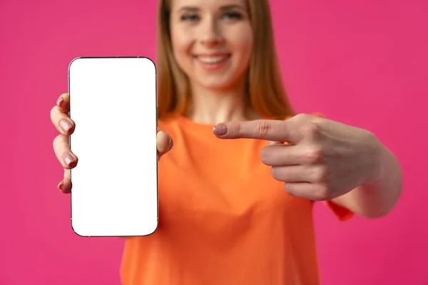 Mujer joven mostrando teléfono inteligente con pantalla blanca aislada contra fondo de color — Foto de Stock