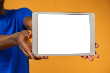Sarı arkaplan üzerinde dijital tablet gösteren Afrikalı adam.