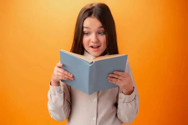 Portret mądrej nastolatki z książkami na pomarańczowym tle — Zdjęcie stockowe