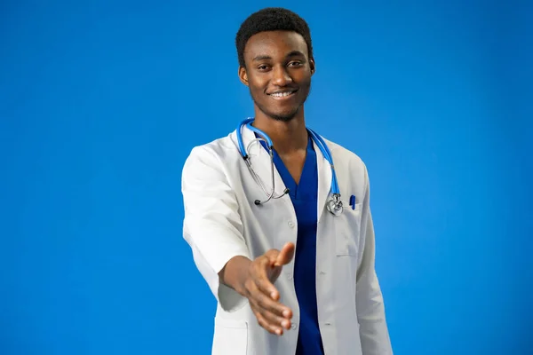 Junger afrikanisch-amerikanischer Mann in Arztuniform und Stethoskop im blauen Studio — Stockfoto