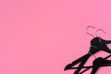 Pembe arkaplandaki boş askılarla düz konum