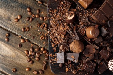 Koyu ahşap masada çikolata ve şeker parçaları..