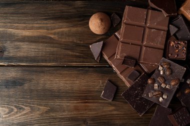 Koyu ahşap arka planda kırılmış çikolatalar.