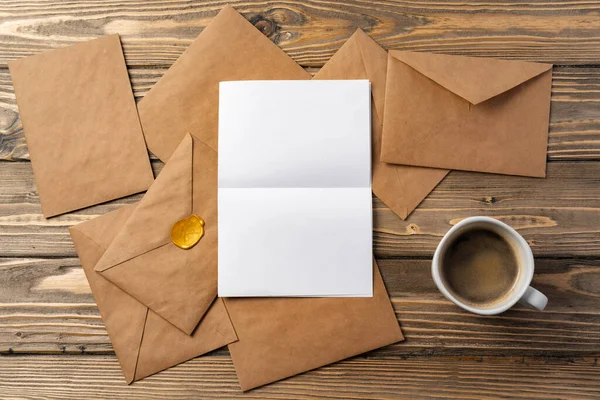 Vintage envelope with empty card, pen on wooden table top view — Stock Photo, Image