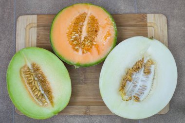 three melons cut in half. Galia, Cantaloupe and Matisse.