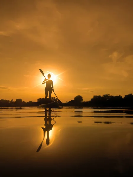 Kobieta Pokładzie Paddle Boarding Zachodzie Słońca Refleksji Nad Wodą — Zdjęcie stockowe