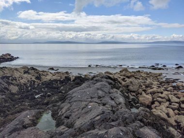 Deniz ve gökyüzü ile kayalık sahil manzarası