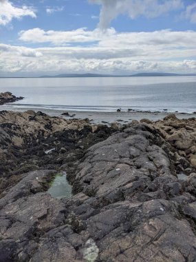 Deniz ve gökyüzü ile kayalık sahil manzarası