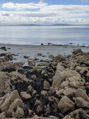 Deniz ve gökyüzü ile kayalık sahil manzarası