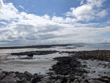 Deniz ve gökyüzü ile kayalık sahil manzarası