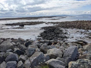 Deniz ve gökyüzü ile kayalık sahil manzarası