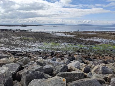 Deniz ve gökyüzü ile kayalık sahil manzarası