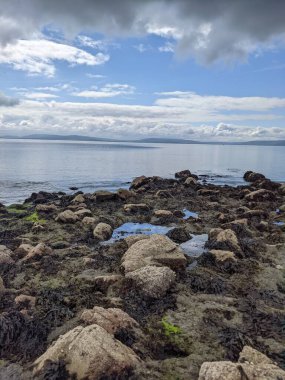 Deniz ve gökyüzü ile kayalık sahil manzarası