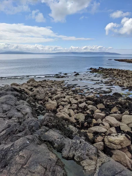 Deniz ve gökyüzü ile kayalık sahil manzarası