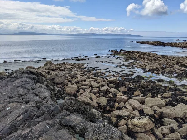 Deniz ve gökyüzü ile kayalık sahil manzarası