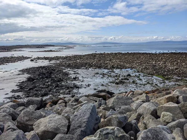 Deniz ve gökyüzü ile kayalık sahil manzarası