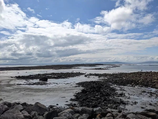 Deniz ve gökyüzü ile kayalık sahil manzarası