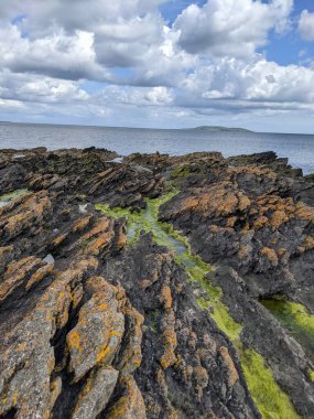 Deniz ve gökyüzü ile kayalık sahil manzarası
