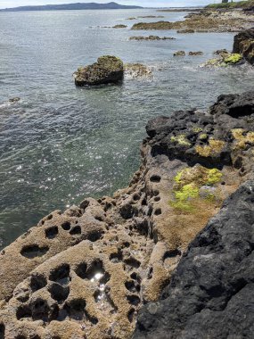 Deniz ve gökyüzü ile kayalık sahil manzarası